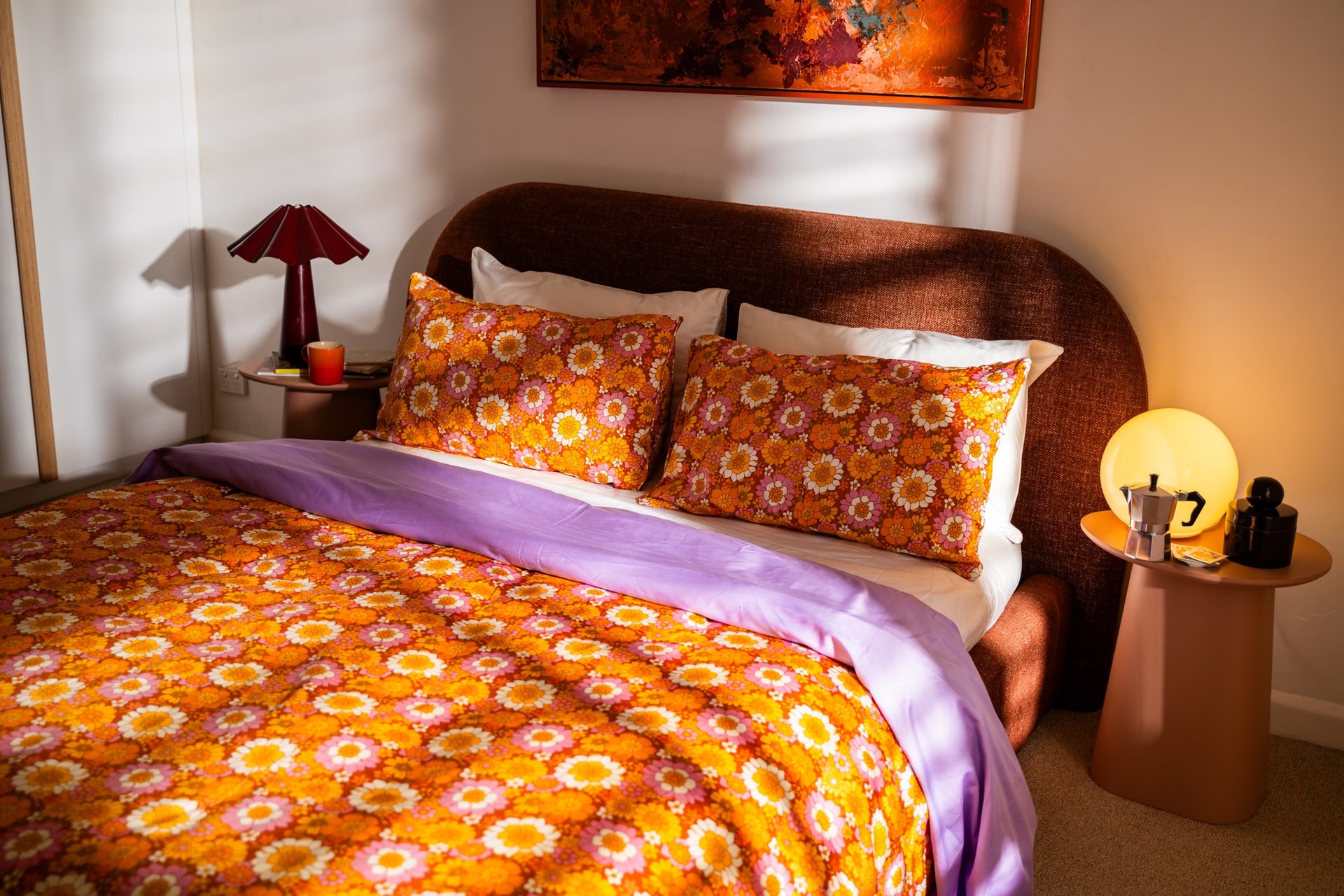 A styled bed with a Flower Child quilt cover, lilac flat sheet and matching pillowcases