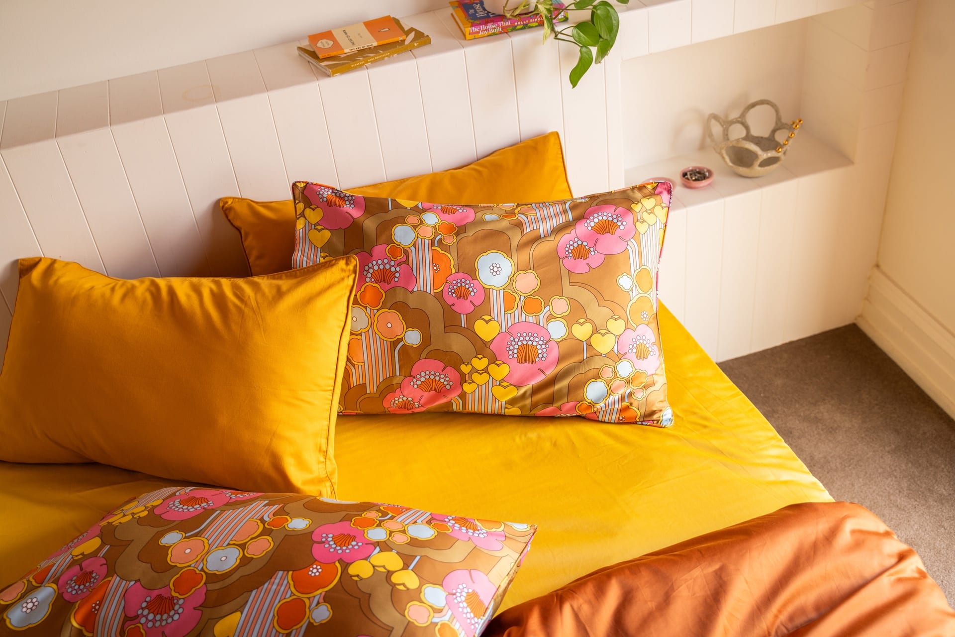 Agatha floral pillowcases styled with rust and green bedding