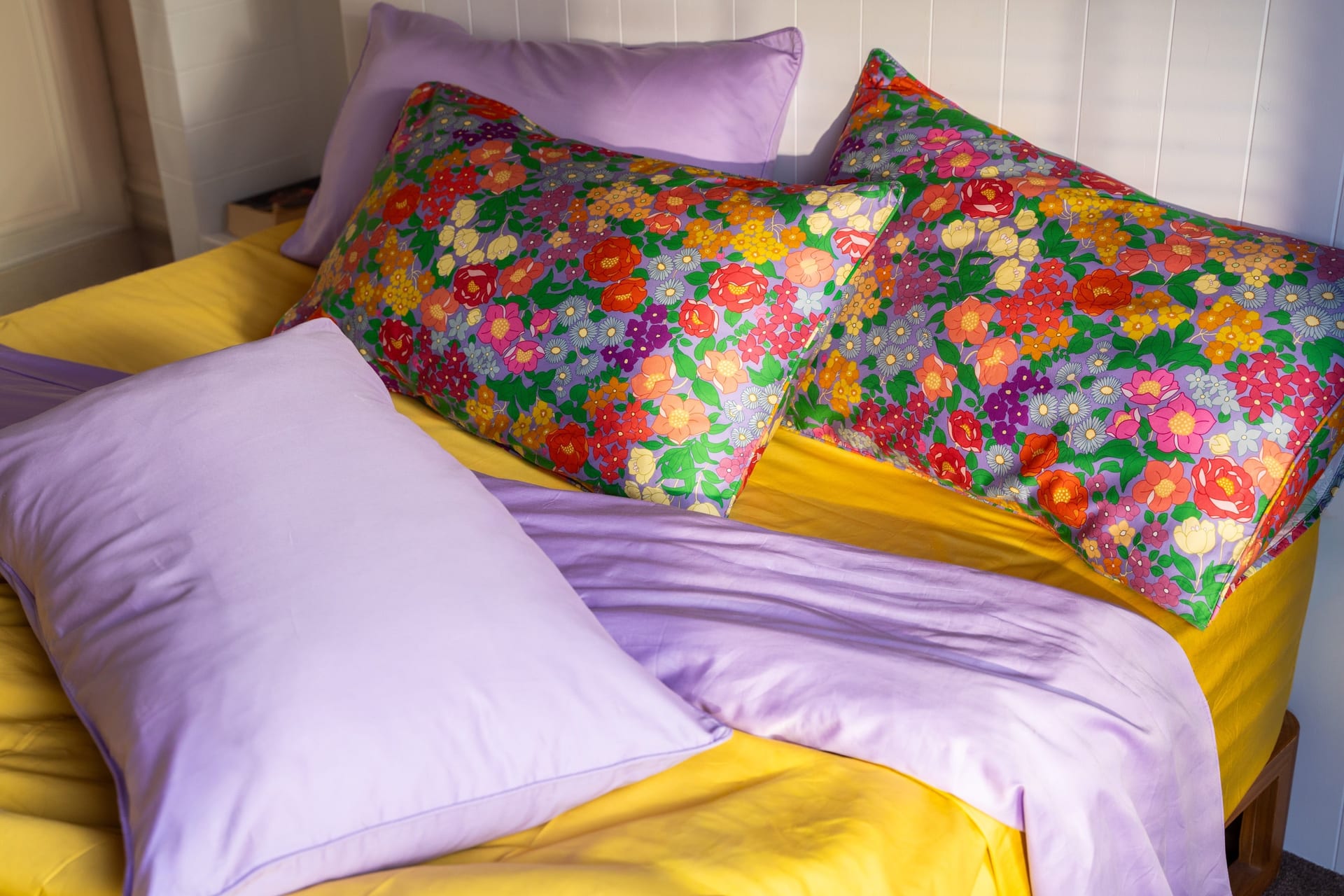 Hazel floral pillowcases styled with lilac and yellow bedding