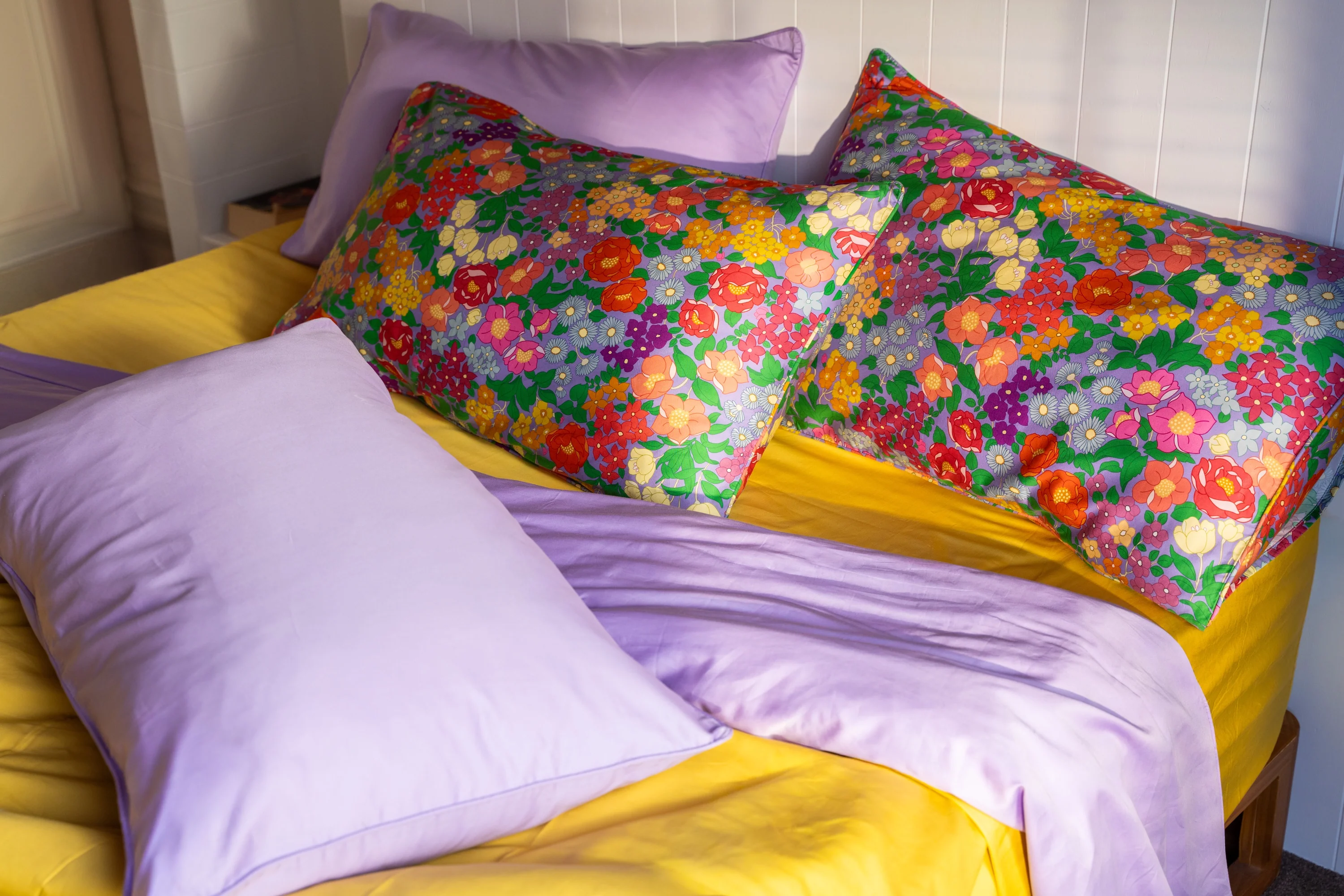 Hazel floral pillowcases styled with lilac and yellow bedding